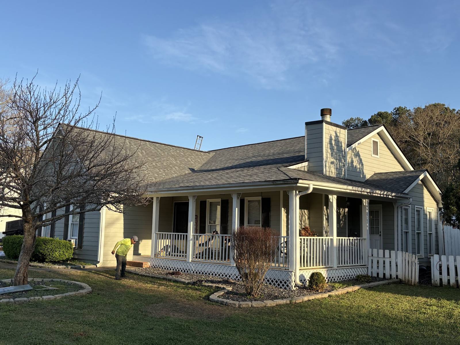 Farmhouse with a wraparound porch under a new roof