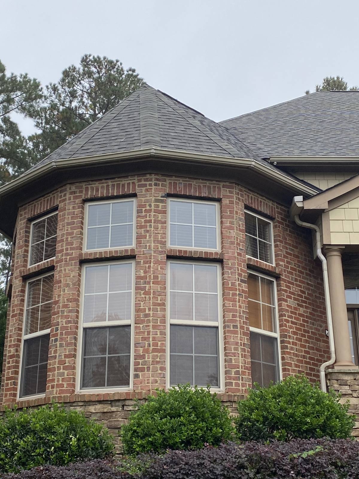 Brick home with a turret, its new roof following the curve of the bay