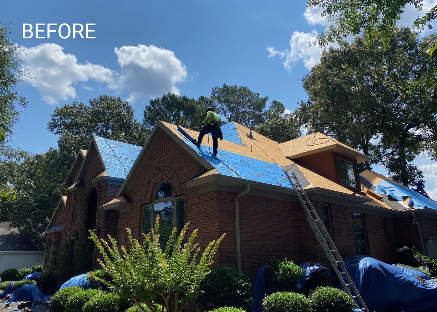 Extra Roofing crew tearing off an old roof, with tarps protecting the yard