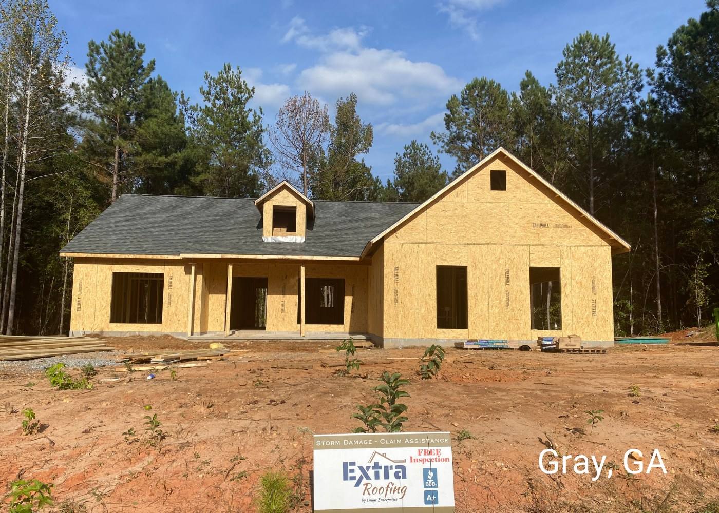 New-build home in Gray, GA with a new roof and an Extra Roofing sign
