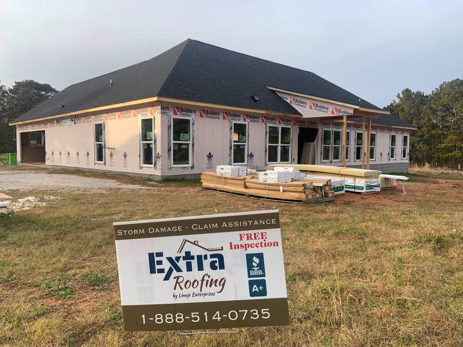 New-build home in McDonough, GA with a new roof and an Extra Roofing sign